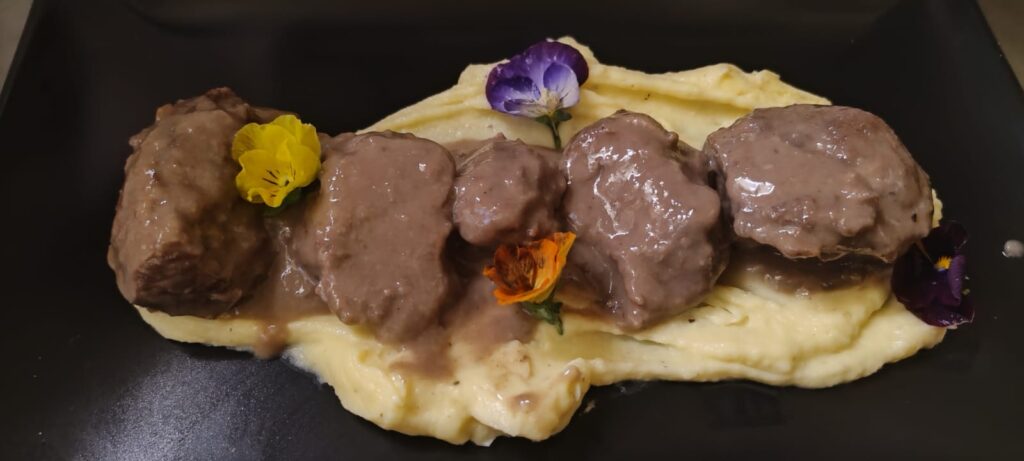 Carrillera al vino tinto con puré de patatas, plato estrella en Pimienta Negra Gastrobar en Valdefuentes, Cáceres